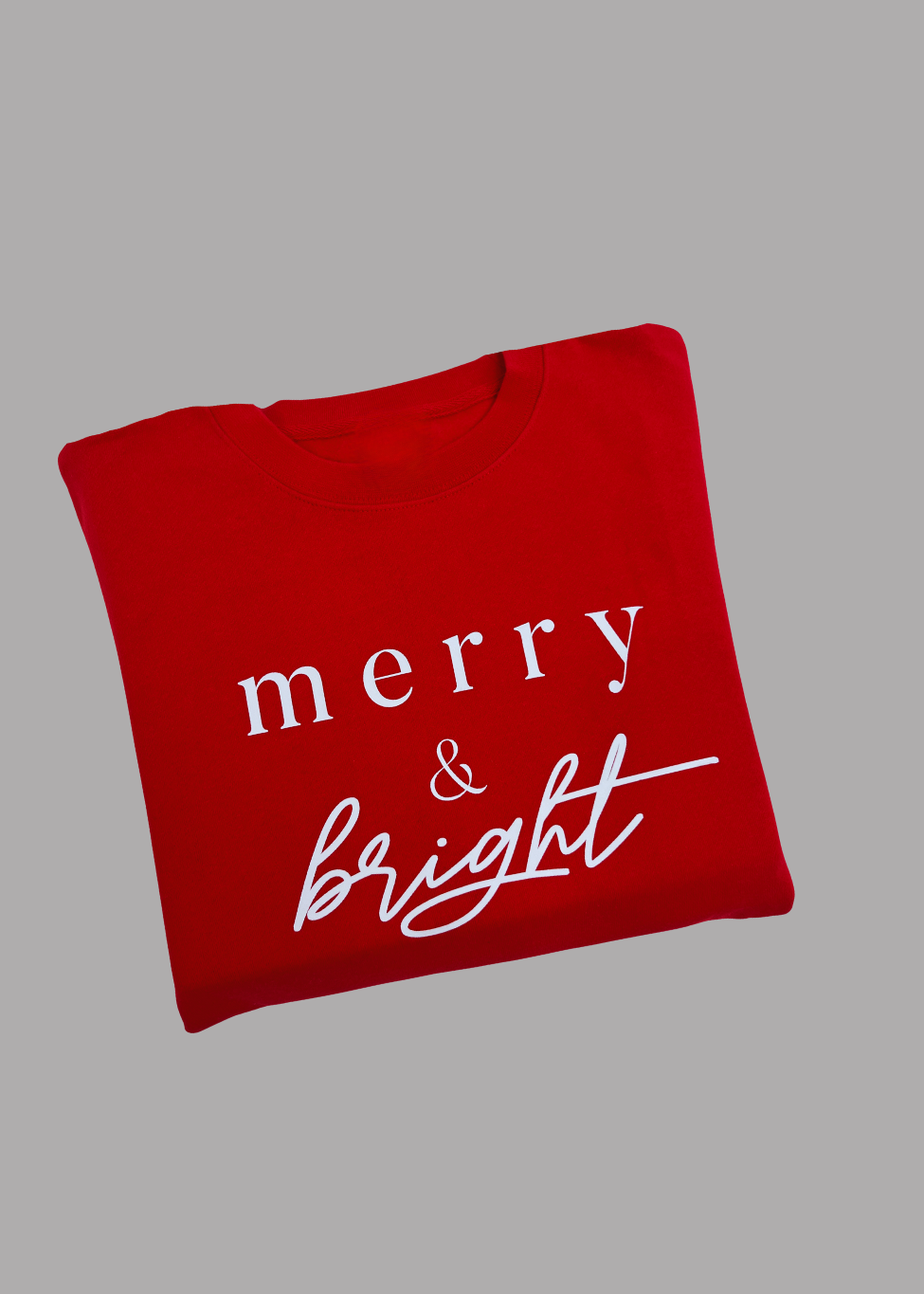 Red sweatshirt with 'merry & bright' text on a gray background