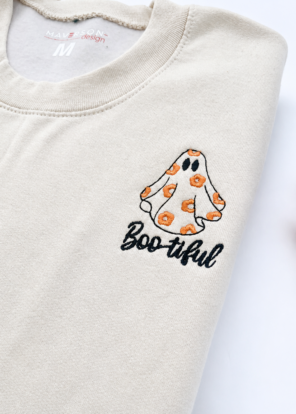 Beige sweatshirt with a ghost design and 'Boo-tiful' text on a white background
