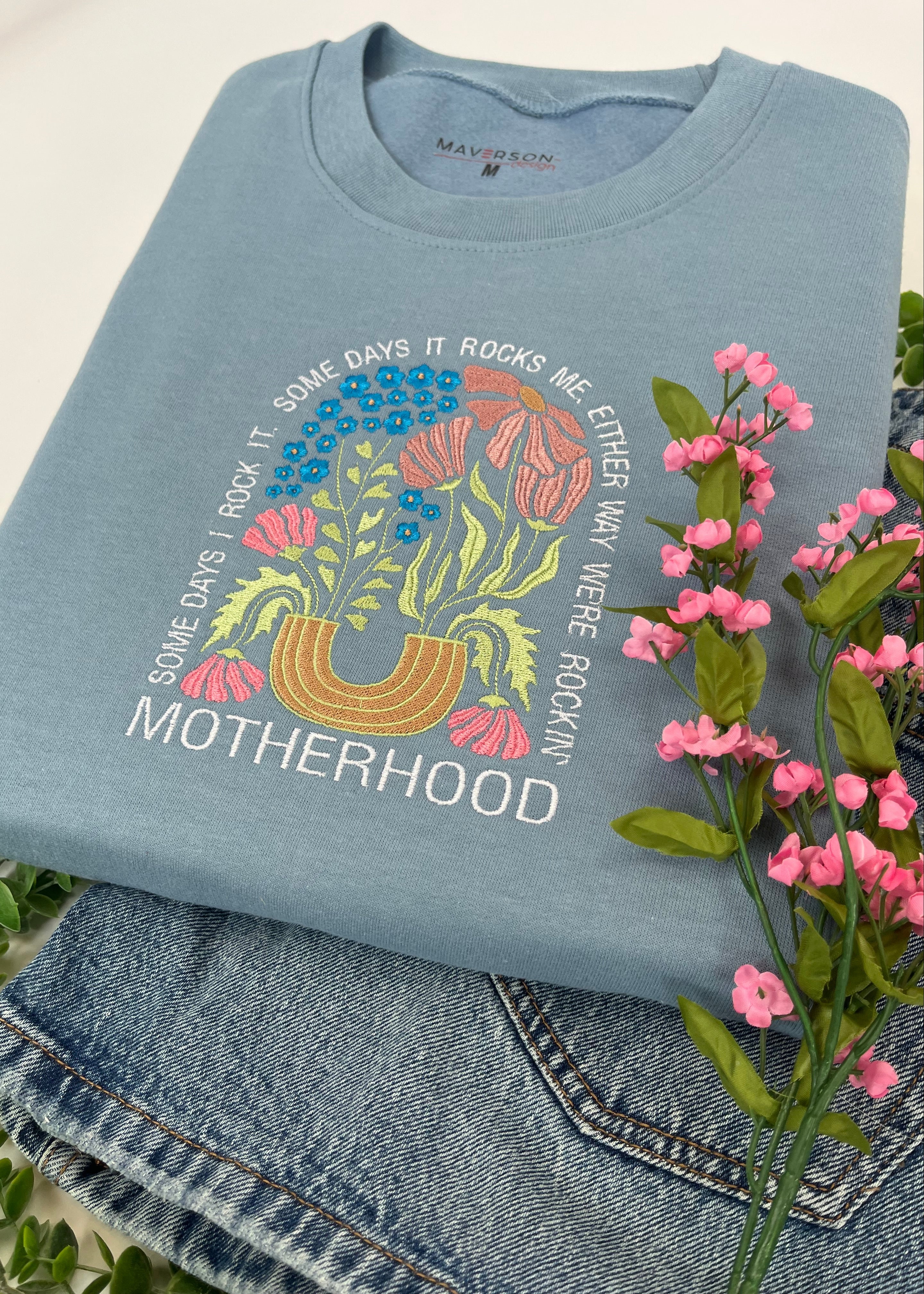 baby blue crewneck sweatshirt with colorful embroidery and text 'Motherhood rockin'